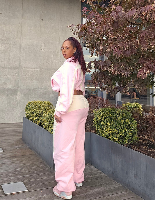Person wearing a pink outfit standing on a stone path with trees in the background