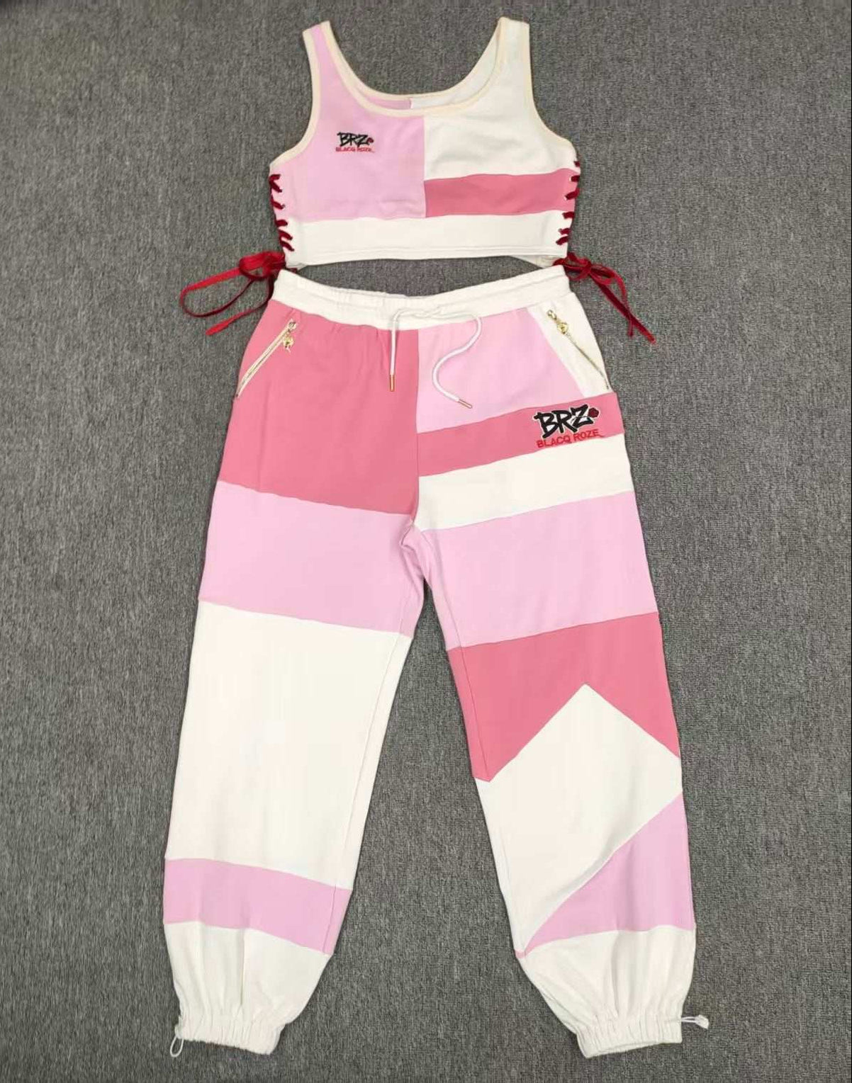 Pink and white outfit with matching pants and tank top on a gray background